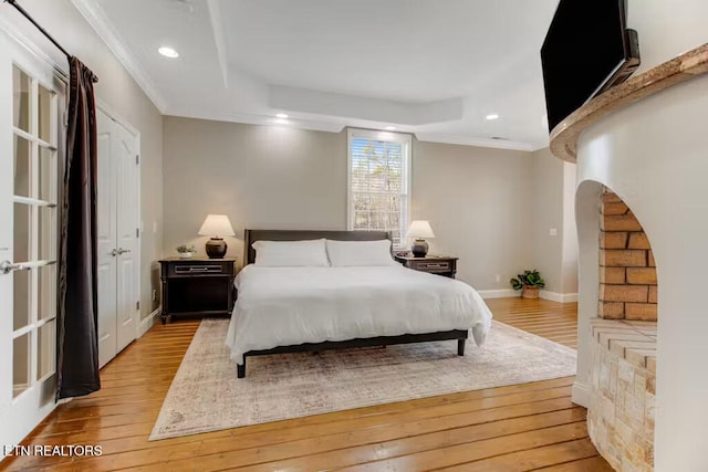 bedroom featuring light wood-type flooring and crown molding