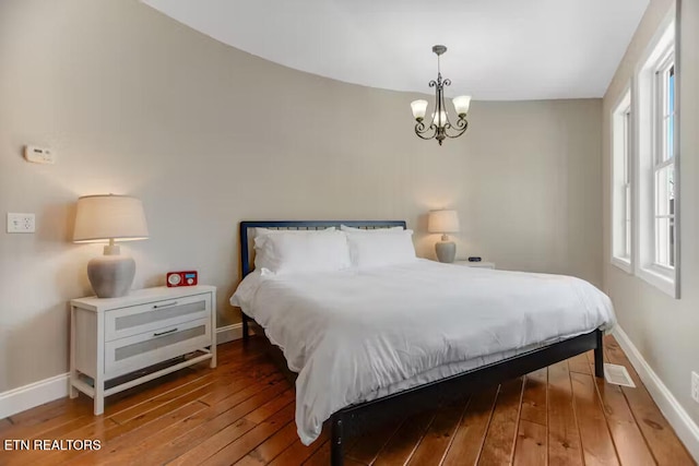 bedroom featuring wood-type flooring and a chandelier