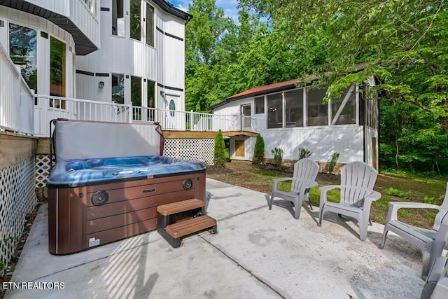 view of patio / terrace with a sunroom, a deck, and a hot tub