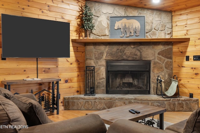 living room featuring hardwood / wood-style flooring, wooden ceiling, a fireplace, and wooden walls