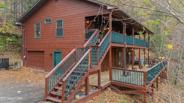 back of house featuring a garage and a deck