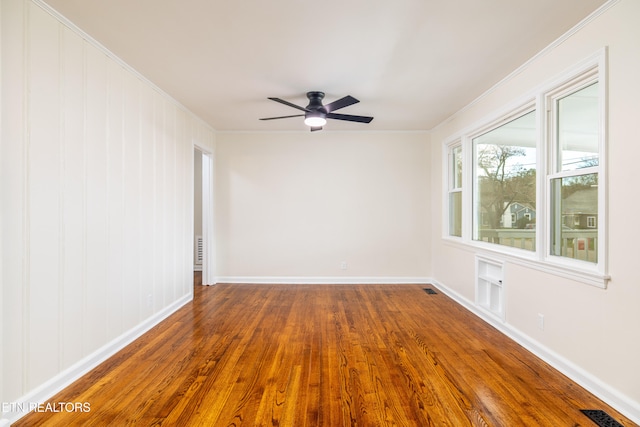 spare room featuring crown molding, dark wood-style floors, and visible vents