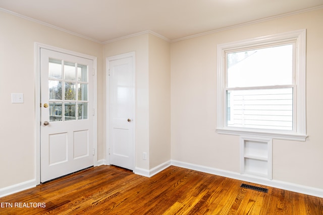 doorway with plenty of natural light, dark hardwood / wood-style floors, and ornamental molding