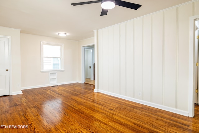 unfurnished room with visible vents, crown molding, dark wood-type flooring, and baseboards