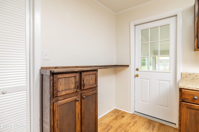 entryway with baseboards, light wood-style flooring, and crown molding