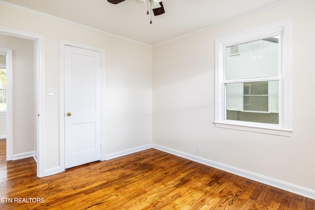 spare room featuring ornamental molding, a ceiling fan, baseboards, and wood finished floors