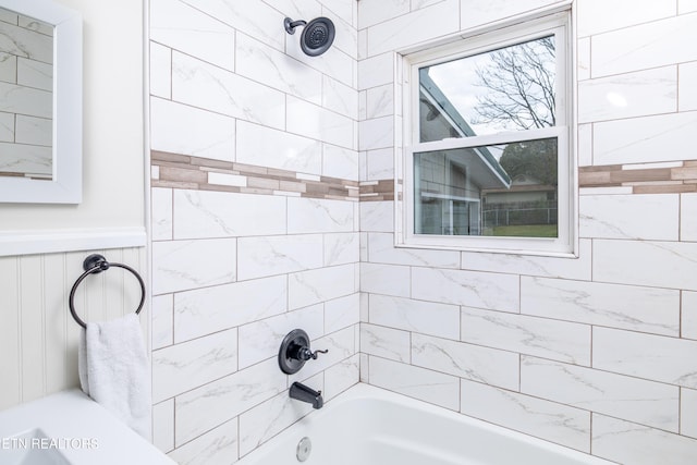 bathroom featuring bathing tub / shower combination and wainscoting