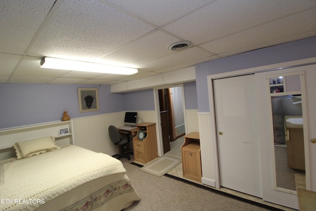 carpeted bedroom with a paneled ceiling