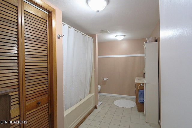 bathroom with tile patterned flooring, toilet, and shower / bath combo with shower curtain