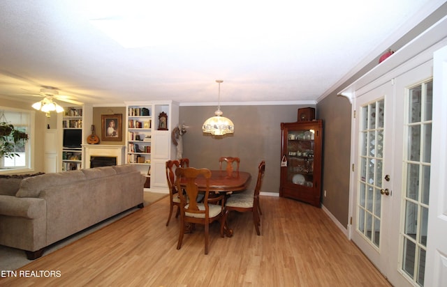 dining space featuring ceiling fan, light hardwood / wood-style floors, crown molding, and french doors