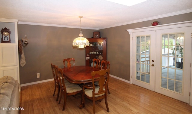 dining room with french doors, light wood-type flooring, and ornamental molding