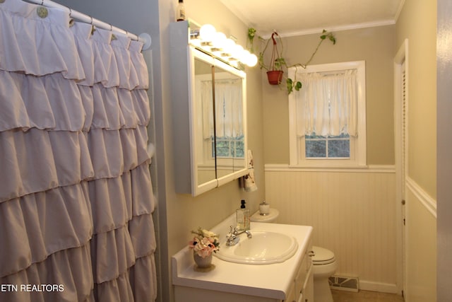 bathroom with vanity, toilet, and crown molding