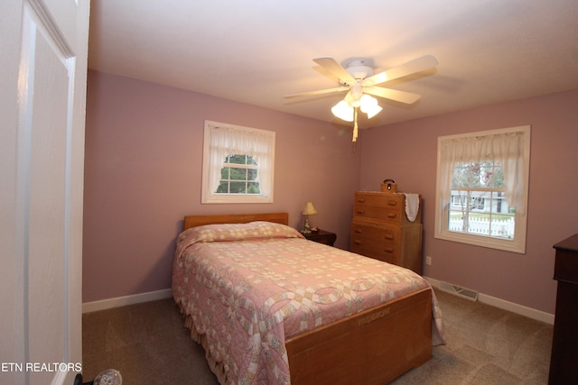 carpeted bedroom featuring ceiling fan and multiple windows