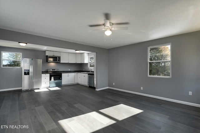 kitchen featuring dark hardwood / wood-style floors, a healthy amount of sunlight, white cabinetry, and appliances with stainless steel finishes