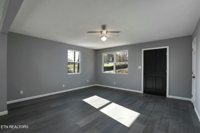 spare room with dark hardwood / wood-style flooring and ceiling fan