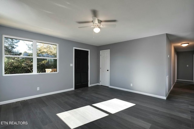 spare room with dark hardwood / wood-style floors and ceiling fan