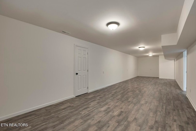 basement with dark hardwood / wood-style flooring