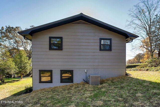 view of property exterior featuring a yard and central AC