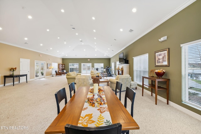 carpeted dining room featuring a healthy amount of sunlight, ornamental molding, and vaulted ceiling