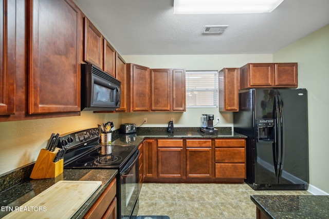 kitchen with black appliances, light tile patterned floors, a textured ceiling, and dark stone counters