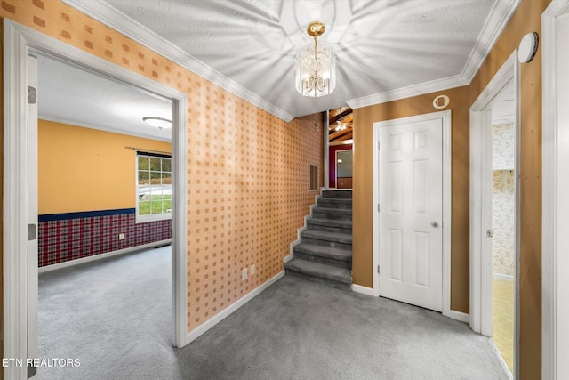 hallway with carpet flooring, a textured ceiling, and crown molding