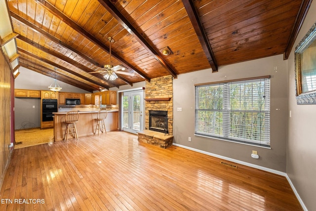 unfurnished living room with light wood-type flooring, lofted ceiling with beams, ceiling fan, and wooden ceiling