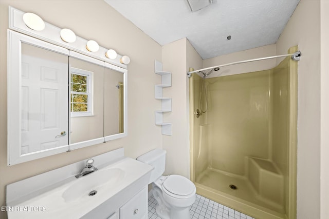 bathroom with tile patterned floors, vanity, a textured ceiling, a shower, and toilet