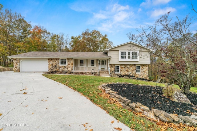 split level home with a front yard, a garage, and covered porch