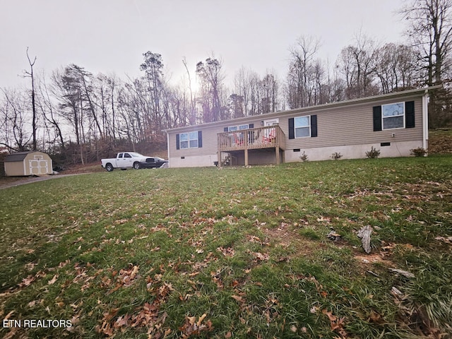 back of property with a yard, a storage unit, and a wooden deck