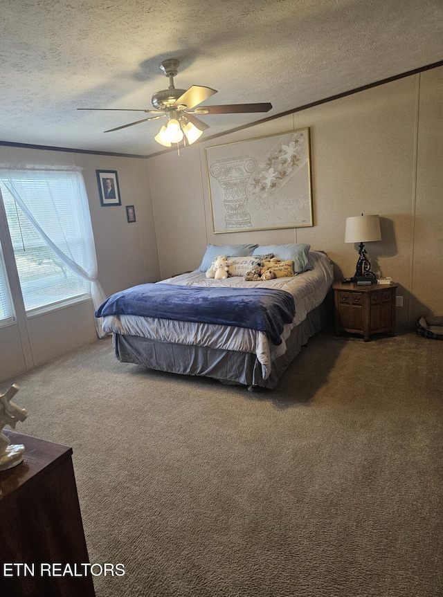 bedroom featuring ceiling fan, carpet floors, and a textured ceiling