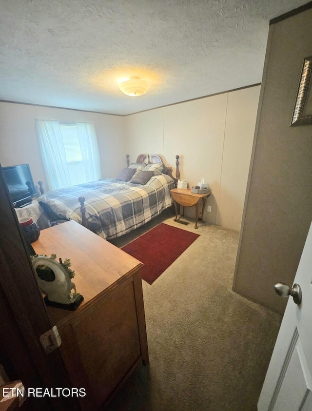 carpeted bedroom featuring a textured ceiling