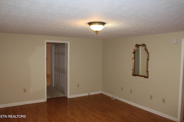 spare room with a textured ceiling and hardwood / wood-style flooring