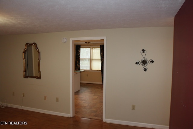 unfurnished room with a textured ceiling and hardwood / wood-style flooring