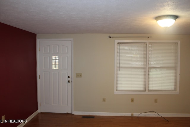 entryway with a textured ceiling and hardwood / wood-style flooring