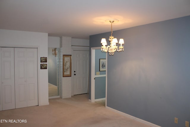 interior space with light colored carpet and an inviting chandelier