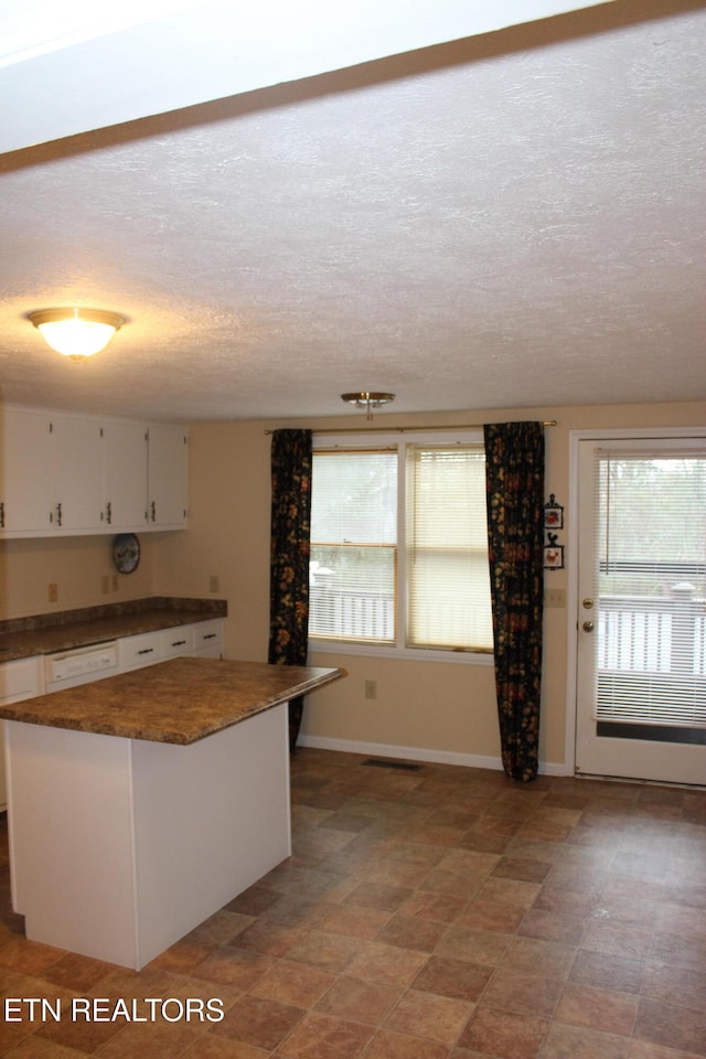 kitchen featuring white cabinets and a textured ceiling