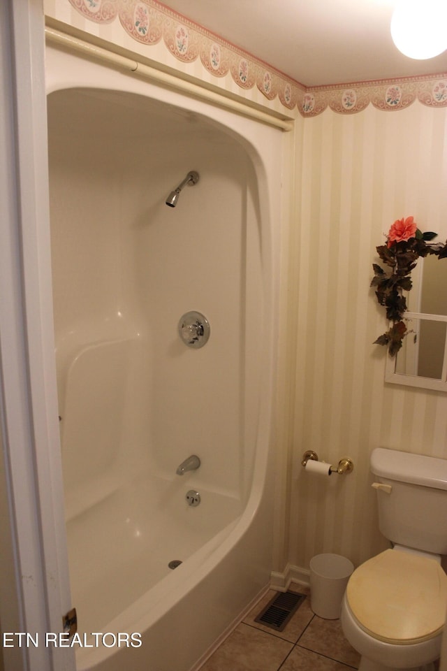 bathroom with toilet, tile patterned floors, and shower / bathtub combination