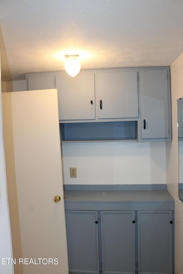 kitchen with gray cabinets and a textured ceiling