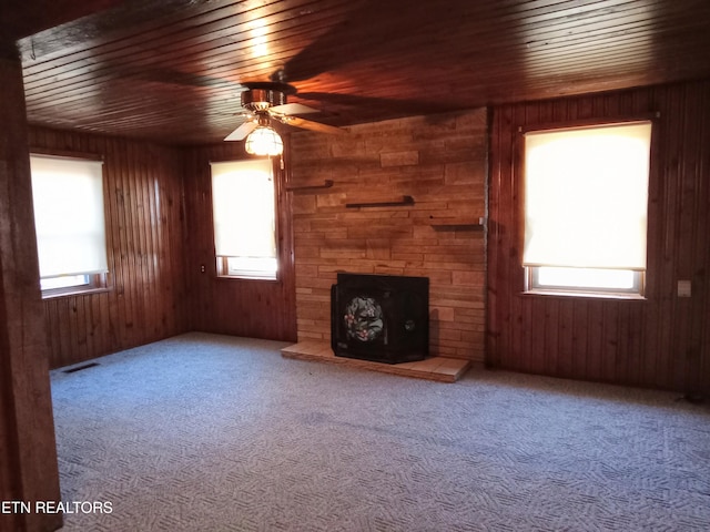 unfurnished living room with plenty of natural light and wooden walls