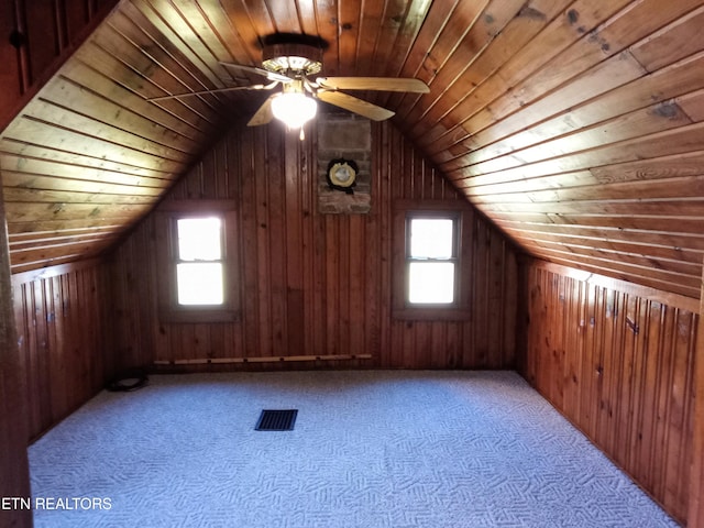 additional living space featuring vaulted ceiling, plenty of natural light, wooden walls, and wood ceiling