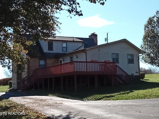 rear view of house with a lawn and a deck