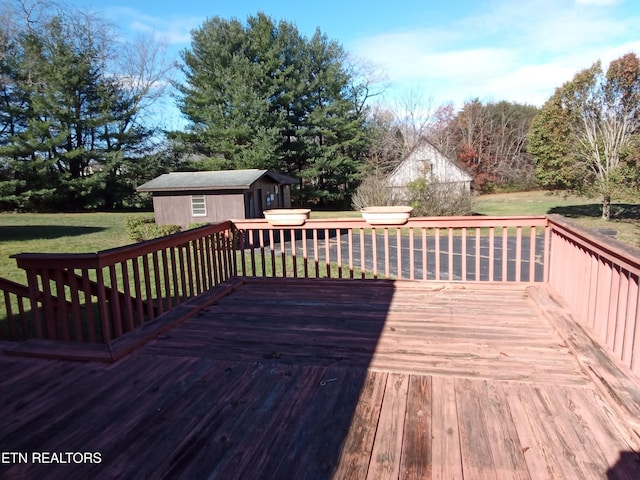 deck featuring a lawn and an outbuilding