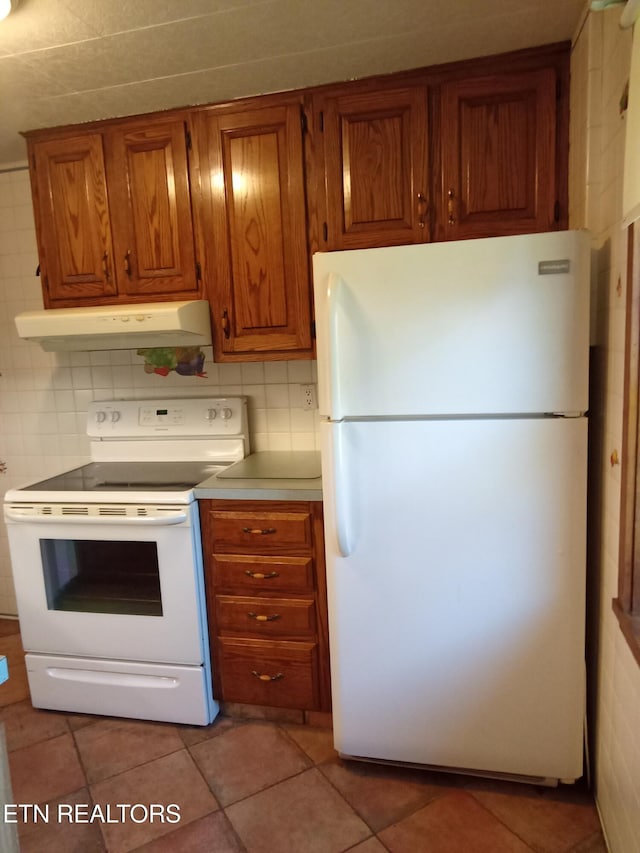 kitchen featuring decorative backsplash, light tile patterned floors, and white appliances