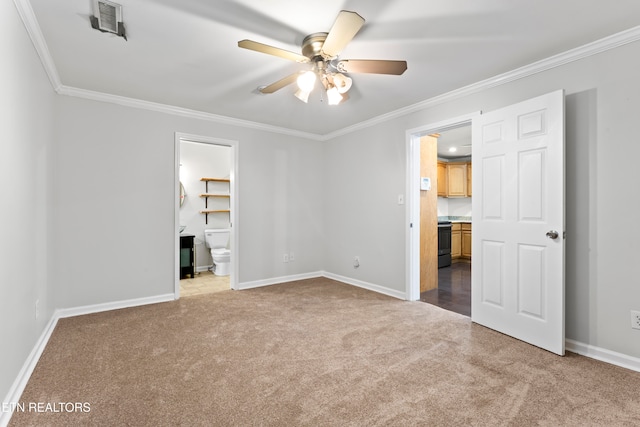 unfurnished bedroom featuring ensuite bath, a spacious closet, ceiling fan, crown molding, and light colored carpet