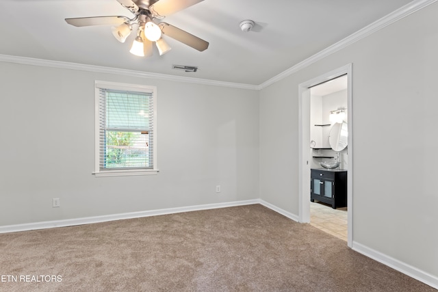 carpeted spare room with ceiling fan and ornamental molding