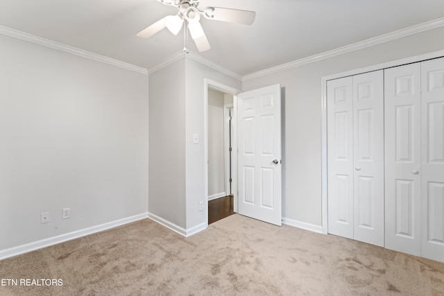 unfurnished bedroom featuring a closet, light colored carpet, ceiling fan, and ornamental molding