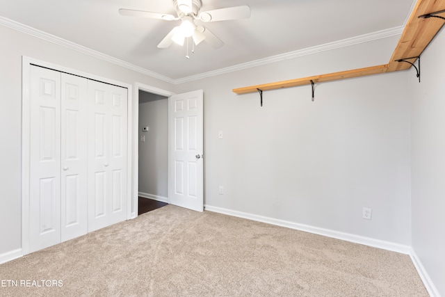 unfurnished bedroom with carpet flooring, a closet, crown molding, and ceiling fan