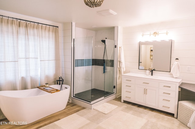 bathroom featuring hardwood / wood-style floors, vanity, and independent shower and bath