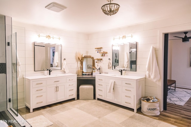 bathroom with vanity, an enclosed shower, wood-type flooring, and tile walls