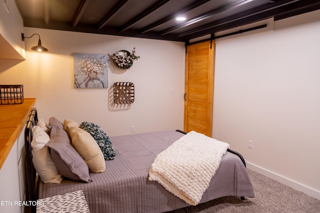 carpeted bedroom featuring a barn door and beamed ceiling